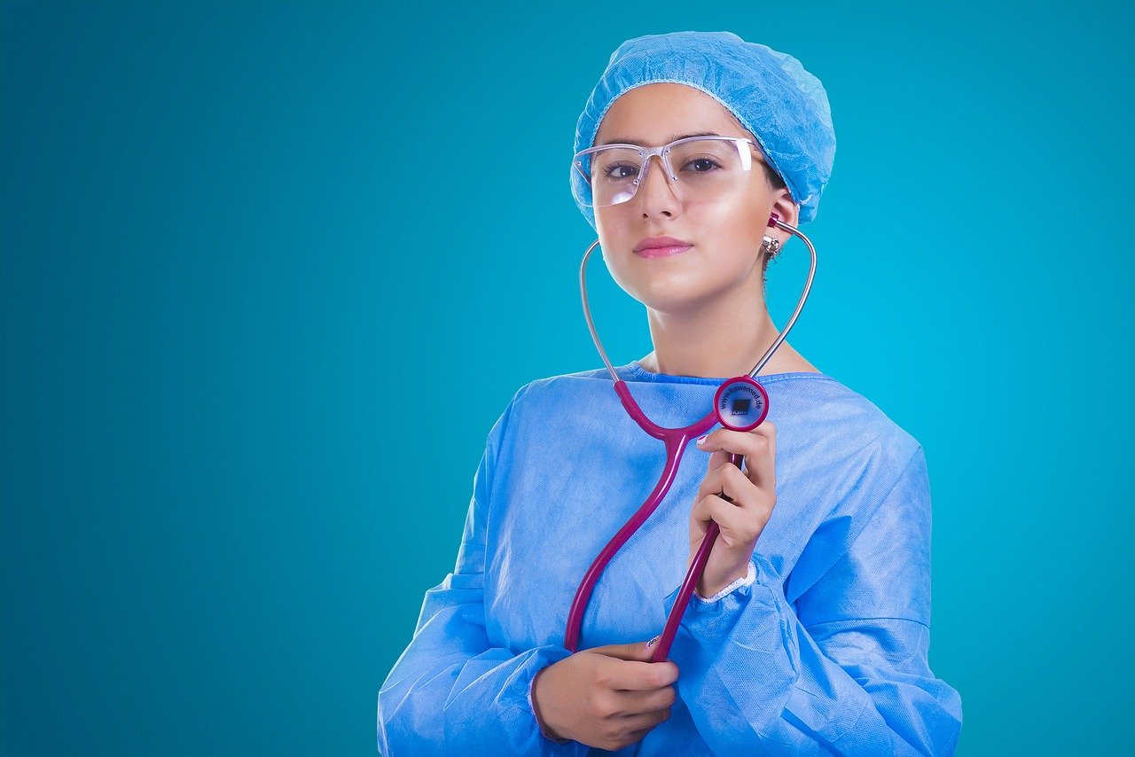 Młoda pielęgniarka w błękitnym kitlu ze stetoskopem